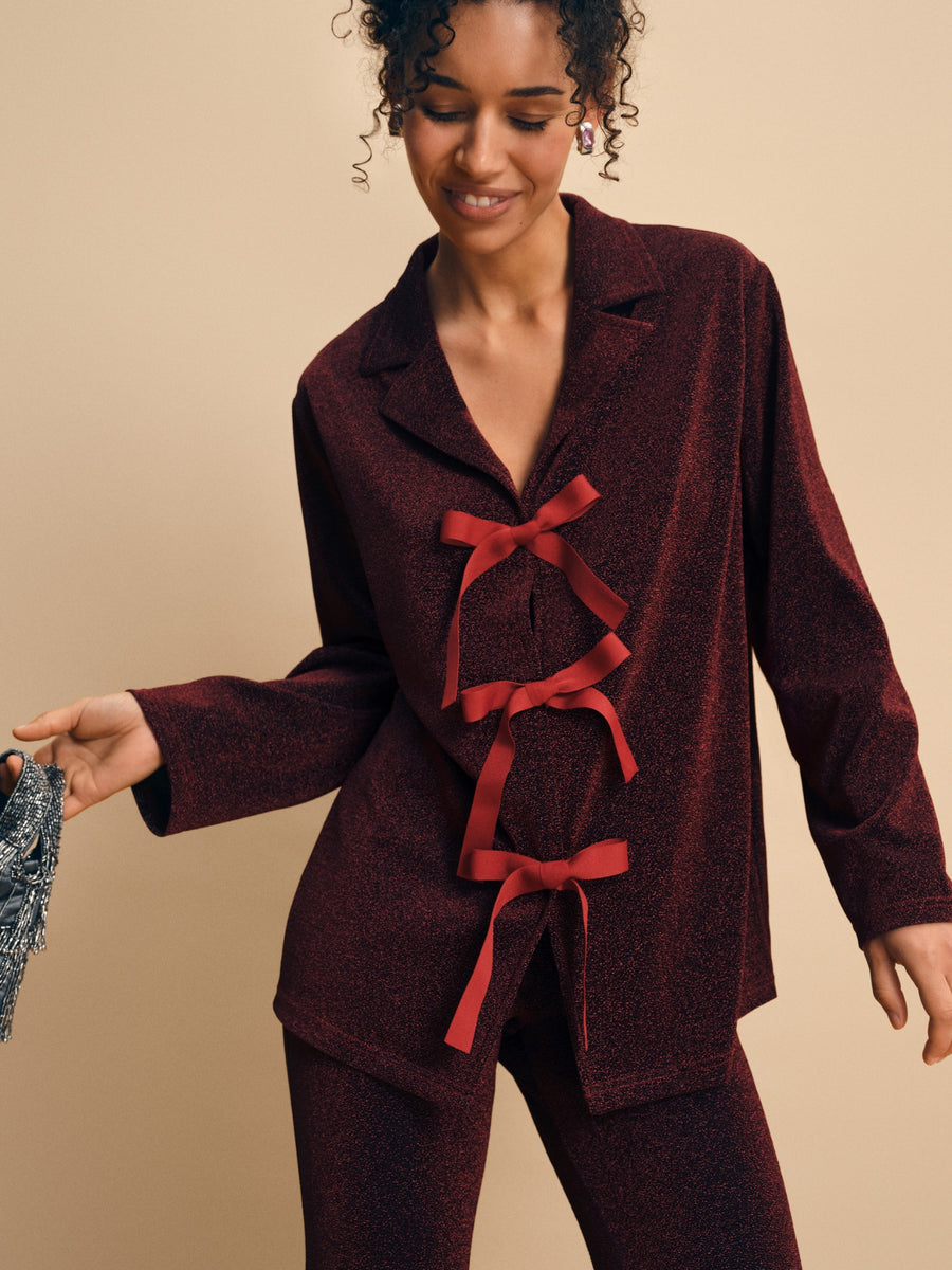 Stardust Lurex Lounge Suit in Burgundy — close-up of bows and fabric