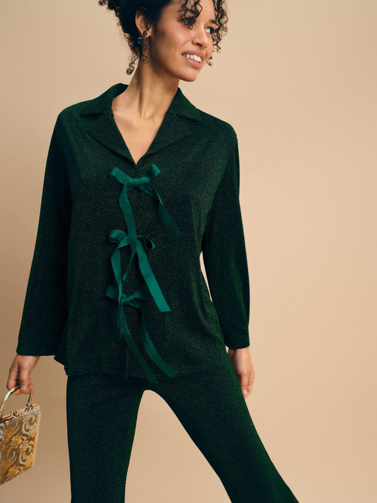 Stardust Lurex Lounge Suit in Green — close-up of bows and fabric
